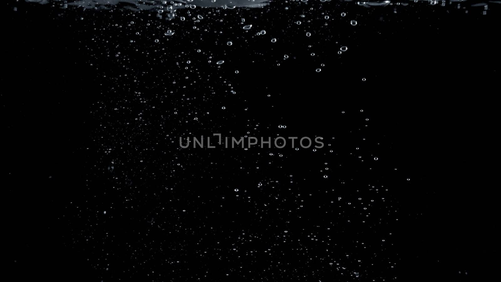 Close-up images of soda water splashing in the water to many little bubbles that make it feel like refreshing and black background
