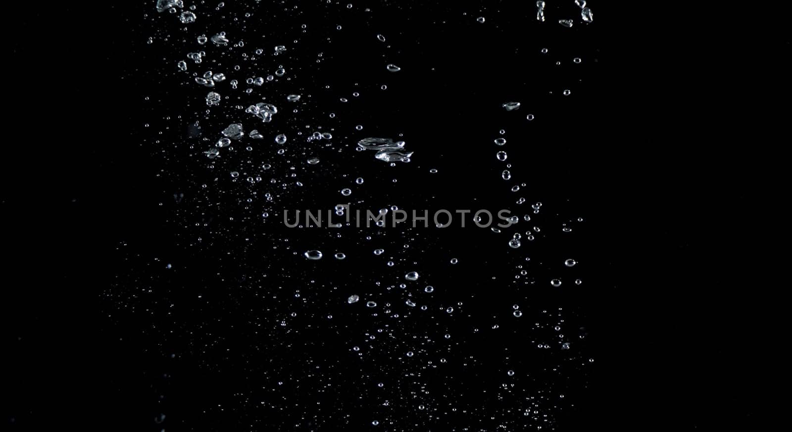 Close-up images of soda water splashing in the water to many little bubbles that make it feel like refreshing and black background