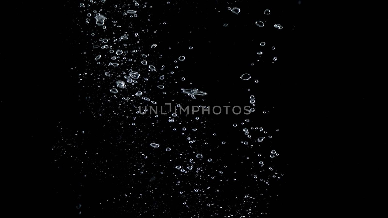Close-up images of soda water splashing in the water to many little bubbles that make it feel like refreshing and black background