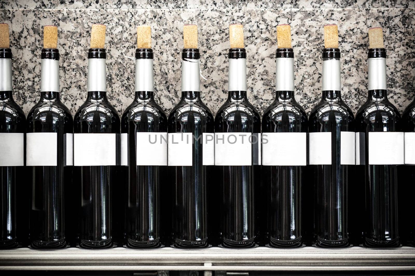 Restaurant shelf full of opened wine red spanish bottles