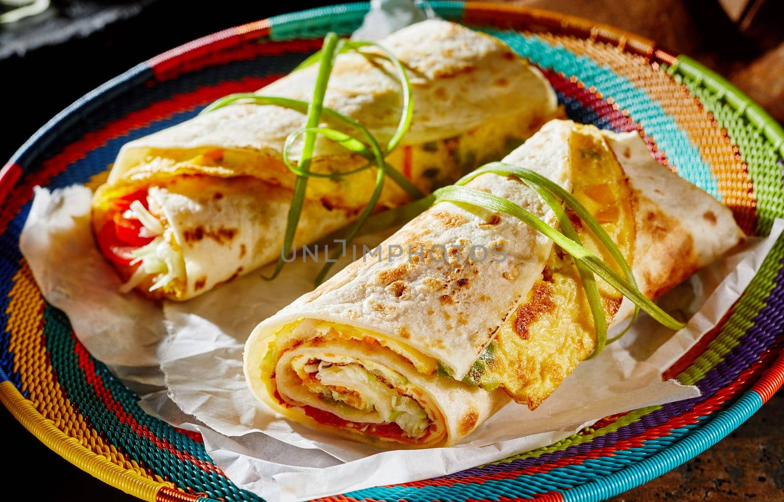 Ugandan Rolex Rolls street food on a brightly colored basket with egg omelette and vegetables rolled in a fried chapati