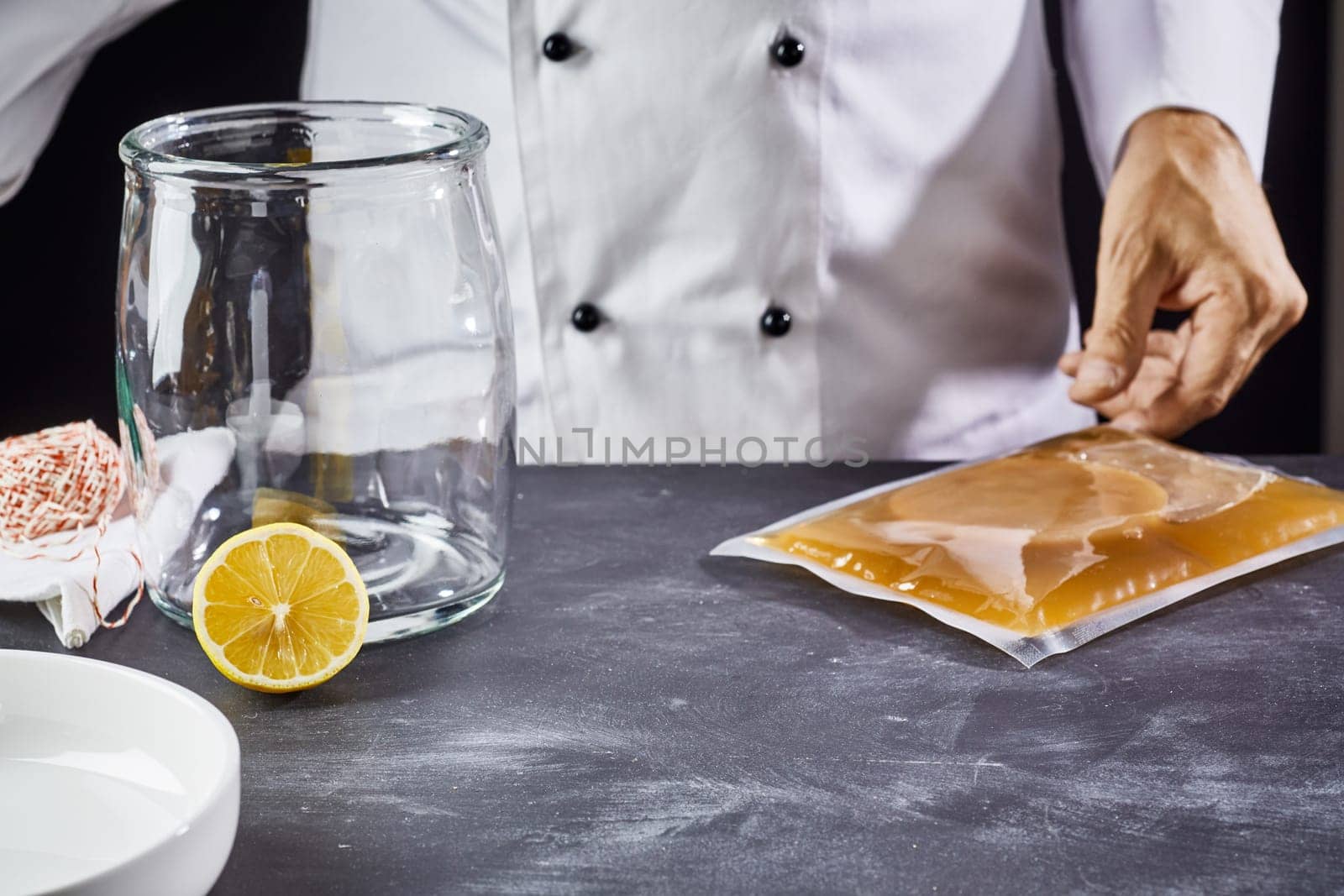 Man preparing to make homemade kombucha reaching for a packaged scoby, mushroom, fungus or mother culture, to start the fermentation
