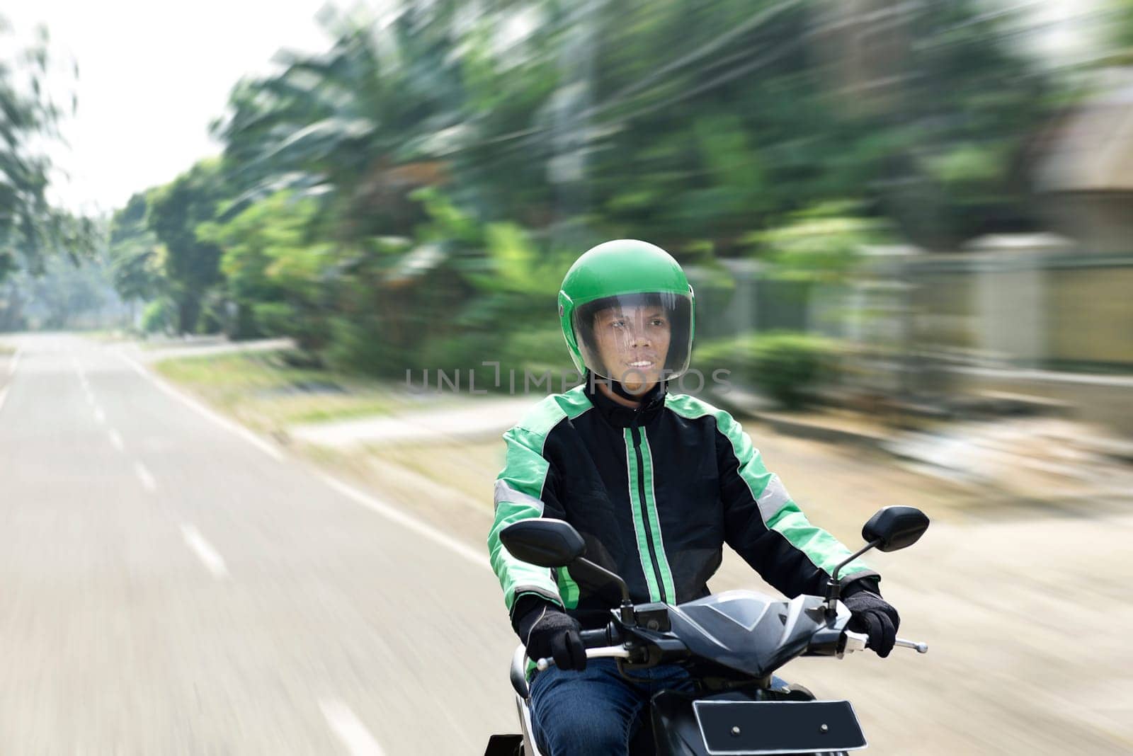 Young man working as motorcycle taxi driver on the urban street