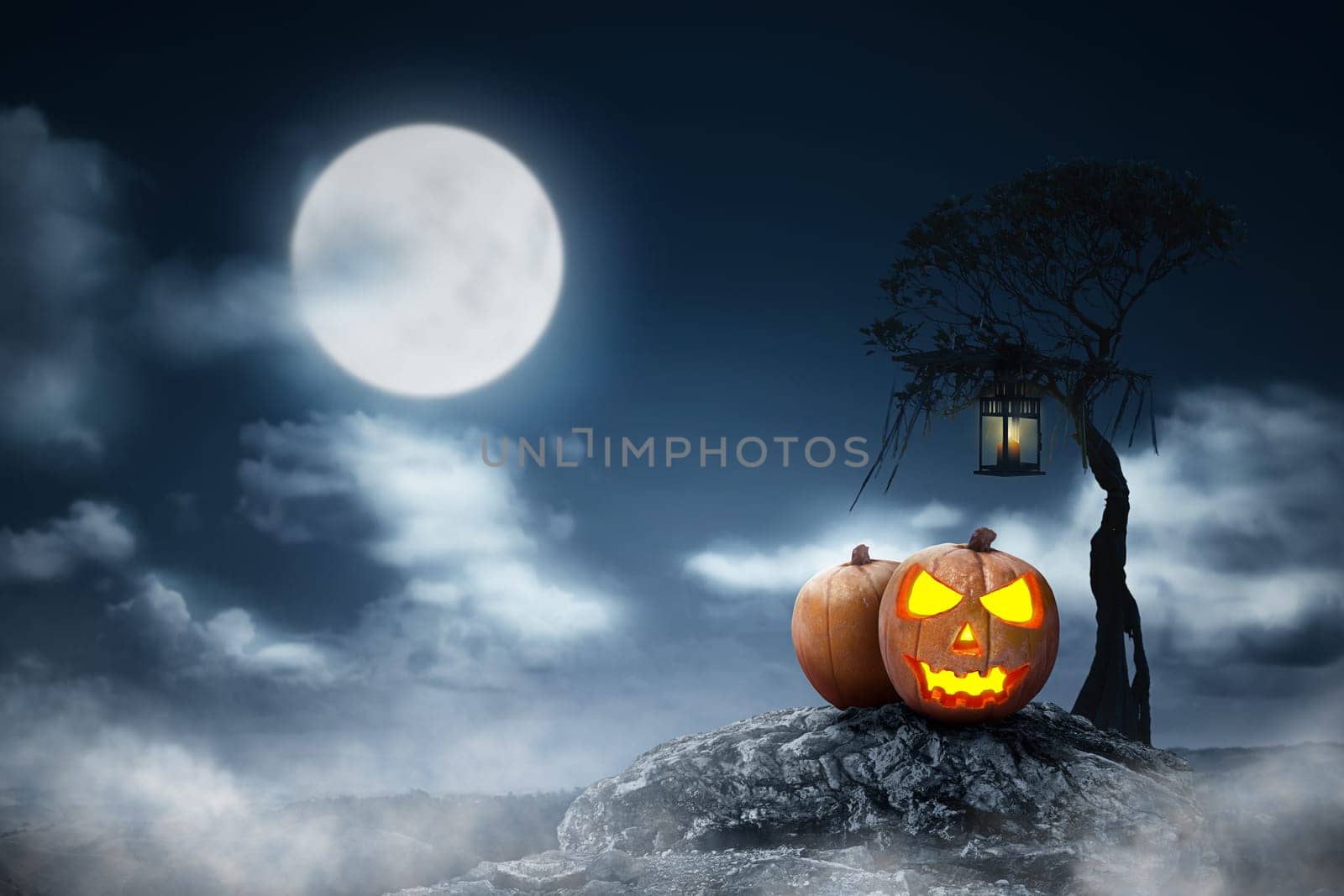 Jack-o-lantern above the rock with lantern hanging on the branch at night. Halloween background