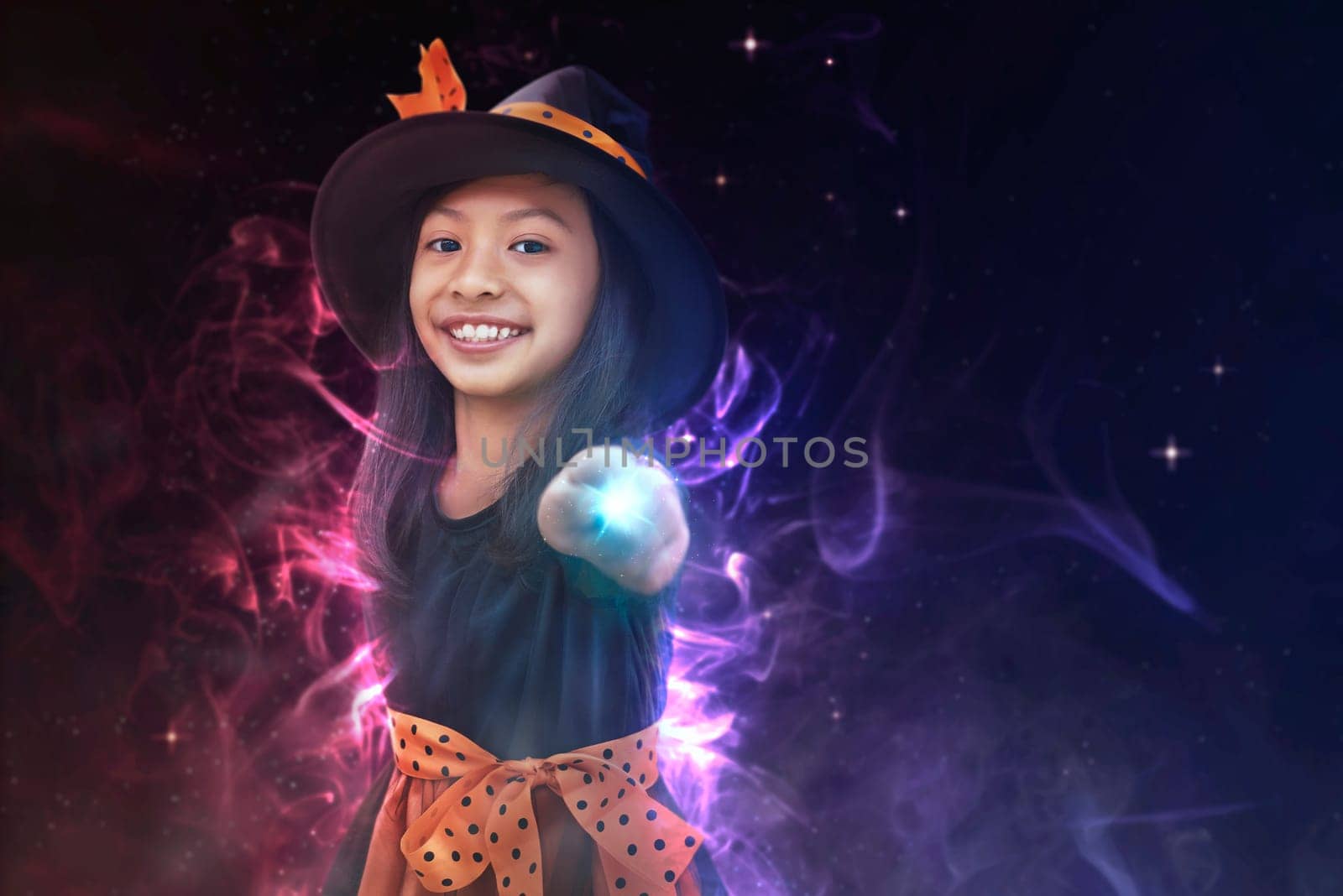 Pretty asian witch girl using her magic wand. Happy Halloween