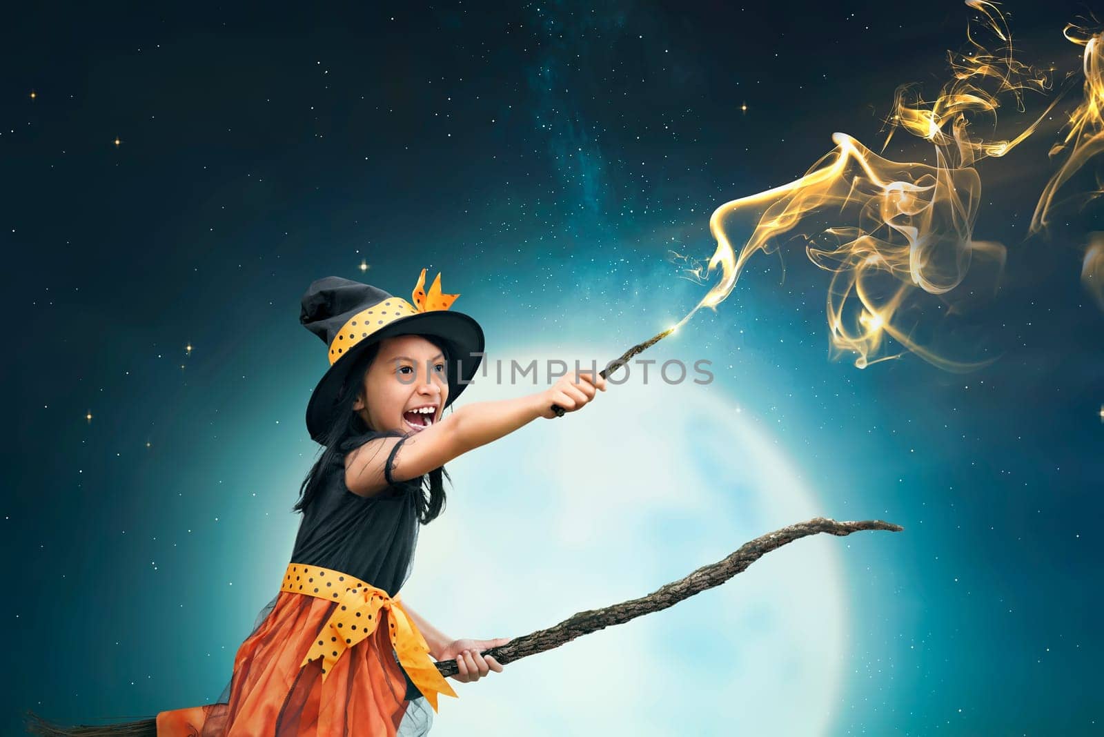 Beautiful asian witch girl using the magic wand with night background