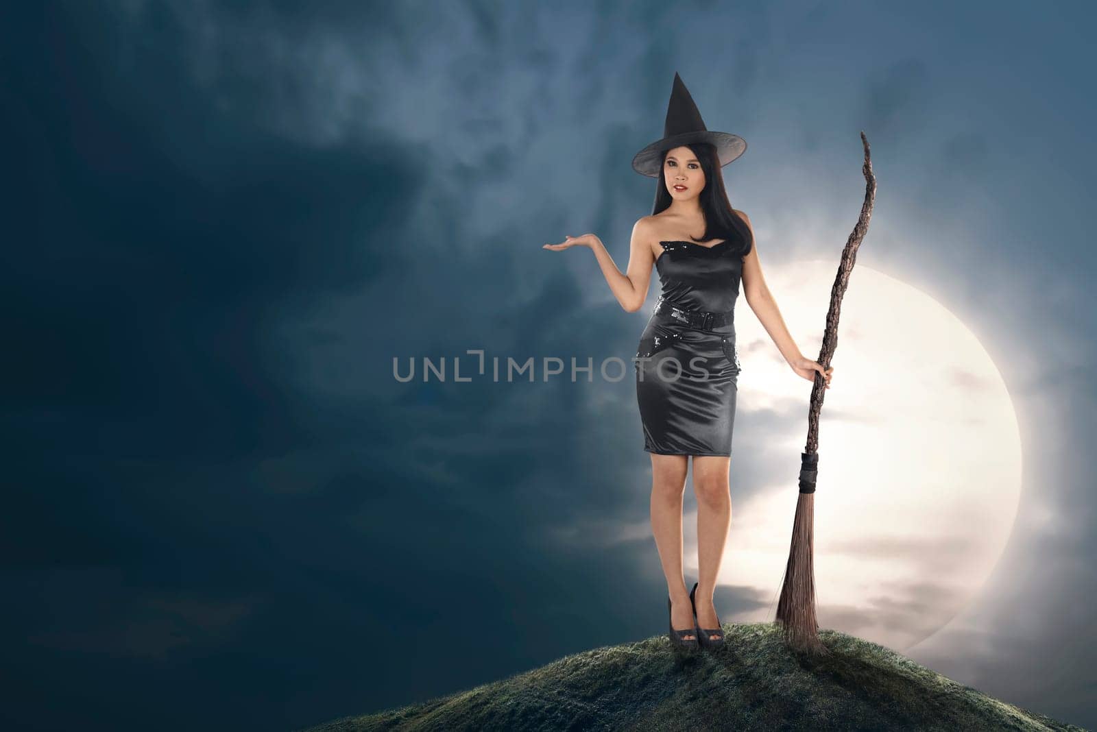 Young asian witch woman with hat and broomstick over moonlight background