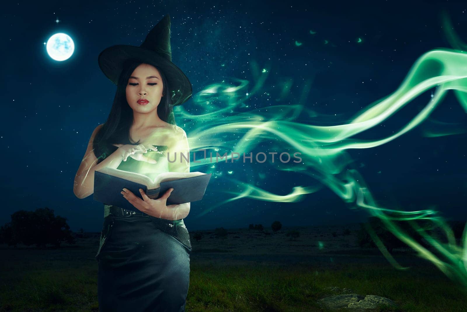 Beautiful asian witch woman learning the magic spell from book on the night