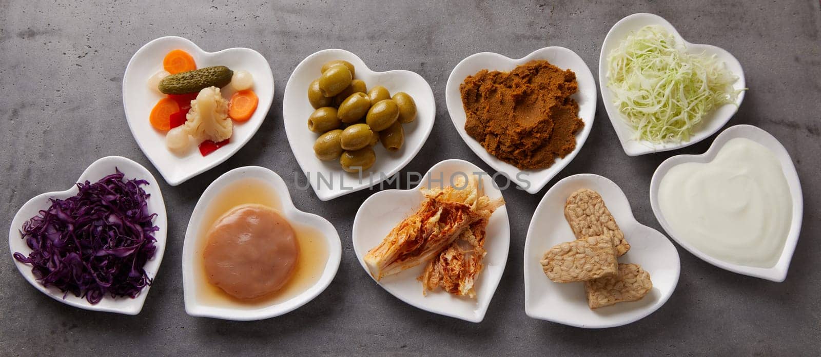 Panorama banner of a variety of healthy fermented foods in heart-shaped dishes in a flat lay still life essential for a healthy gut and immune system
