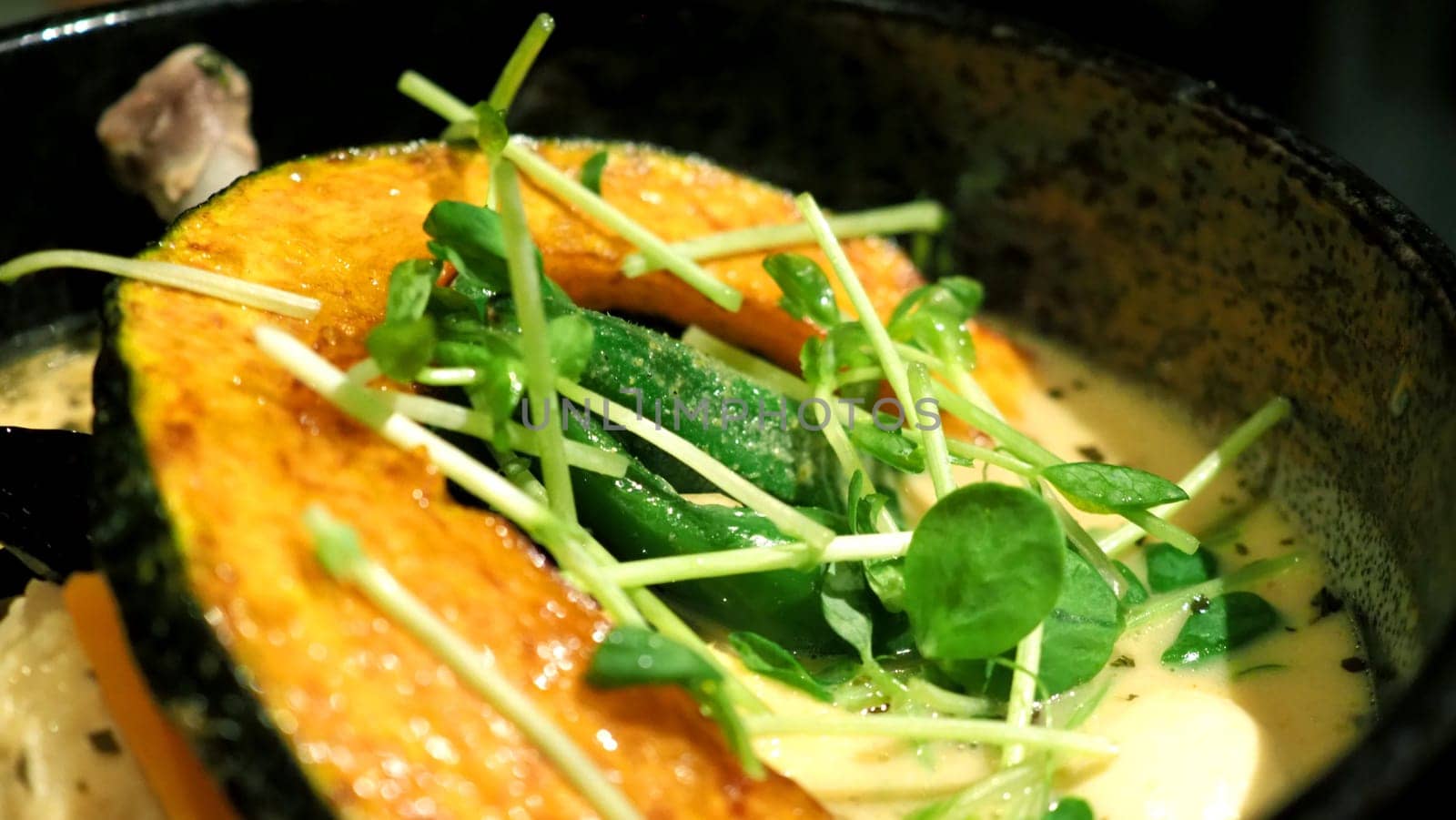 Close-up images of yellow color soup curry with chicken, pork and vegetable in bowl which famous traditional food menu and only found in Hokkaido Sapporo district of Japan