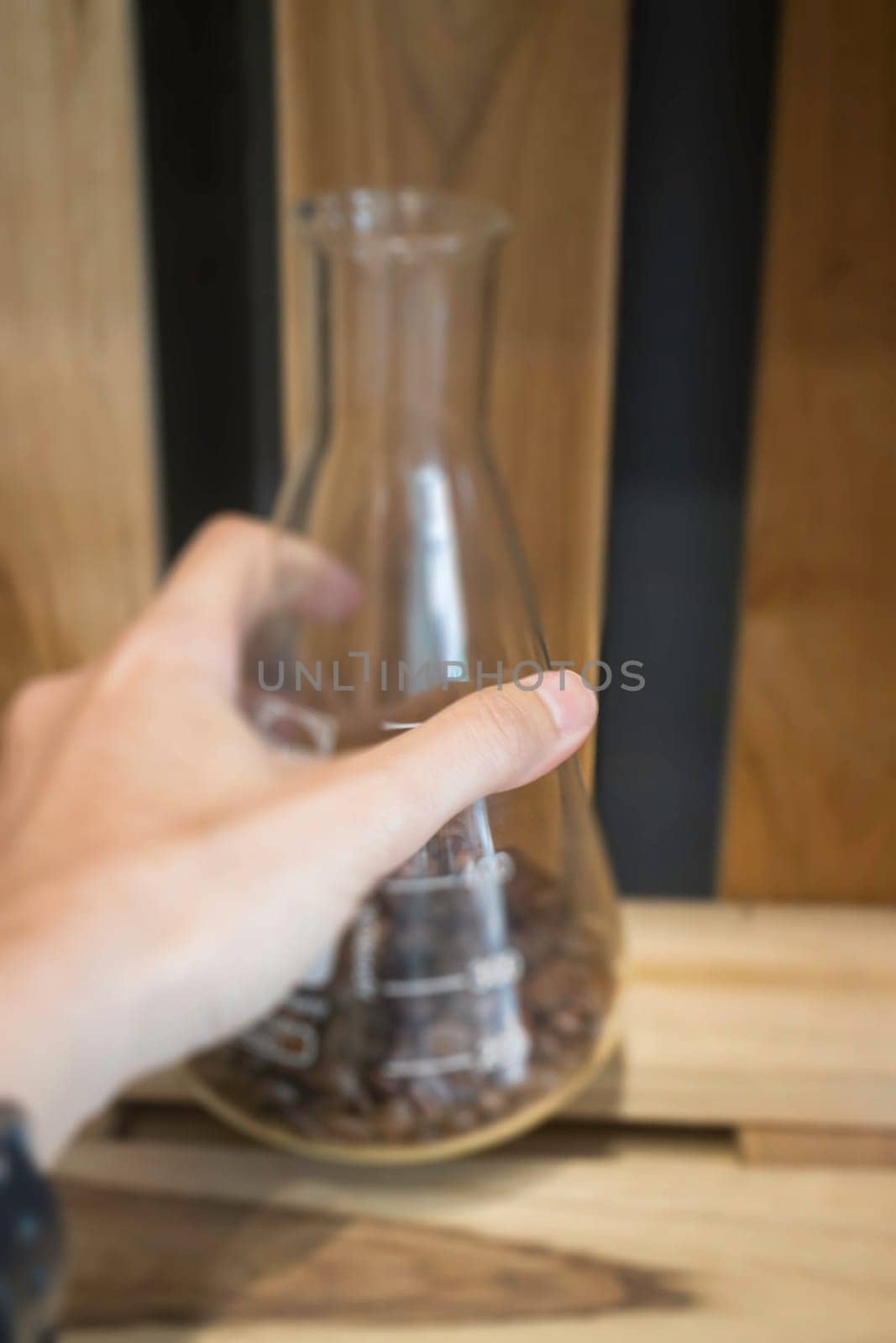 Hand on tube bottle on wooden shelf, stock photo