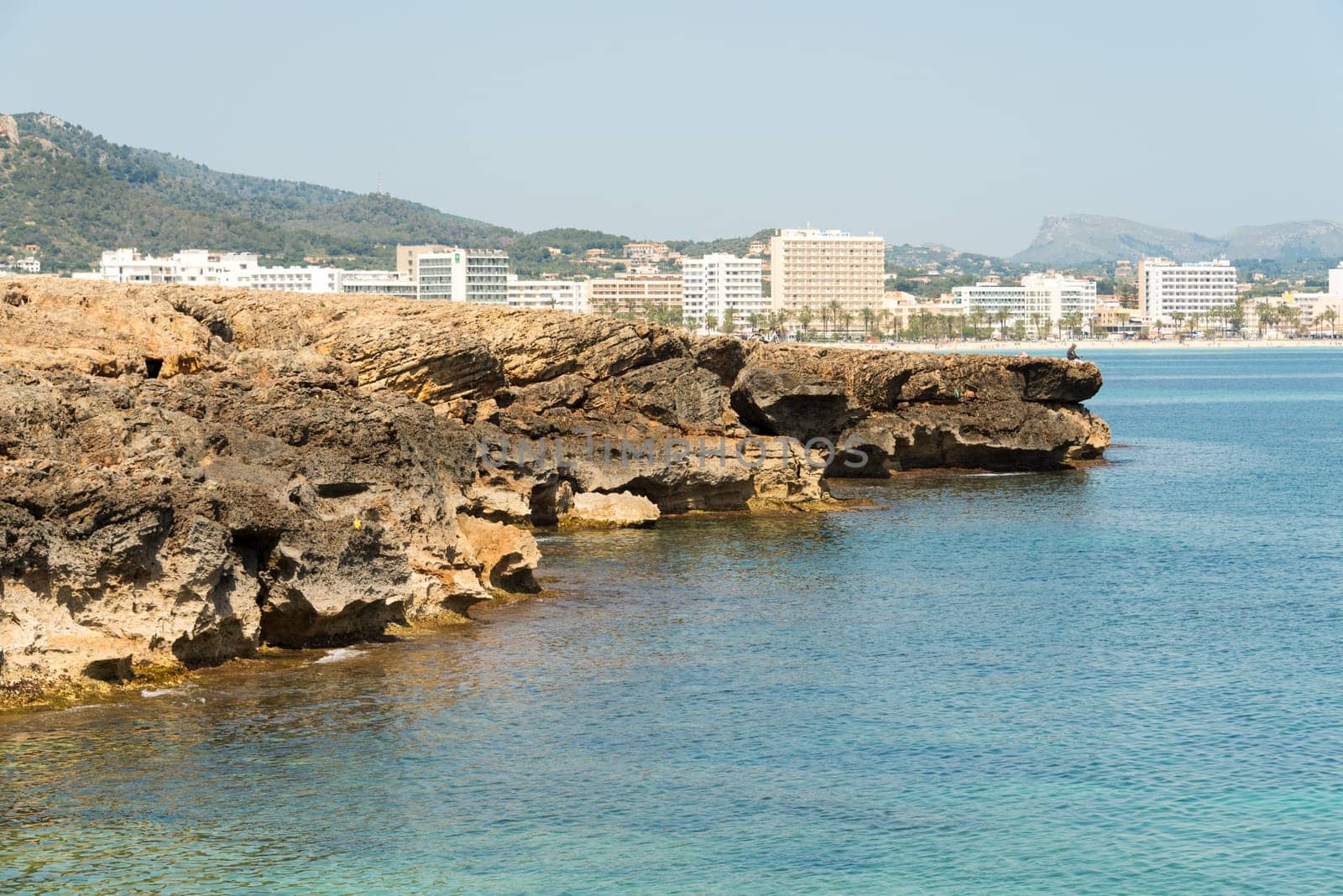 View over the clear turquoise waters of the Mediterranean to the beach of Cala Millor on the Spanish Mediterranean island Mallocra