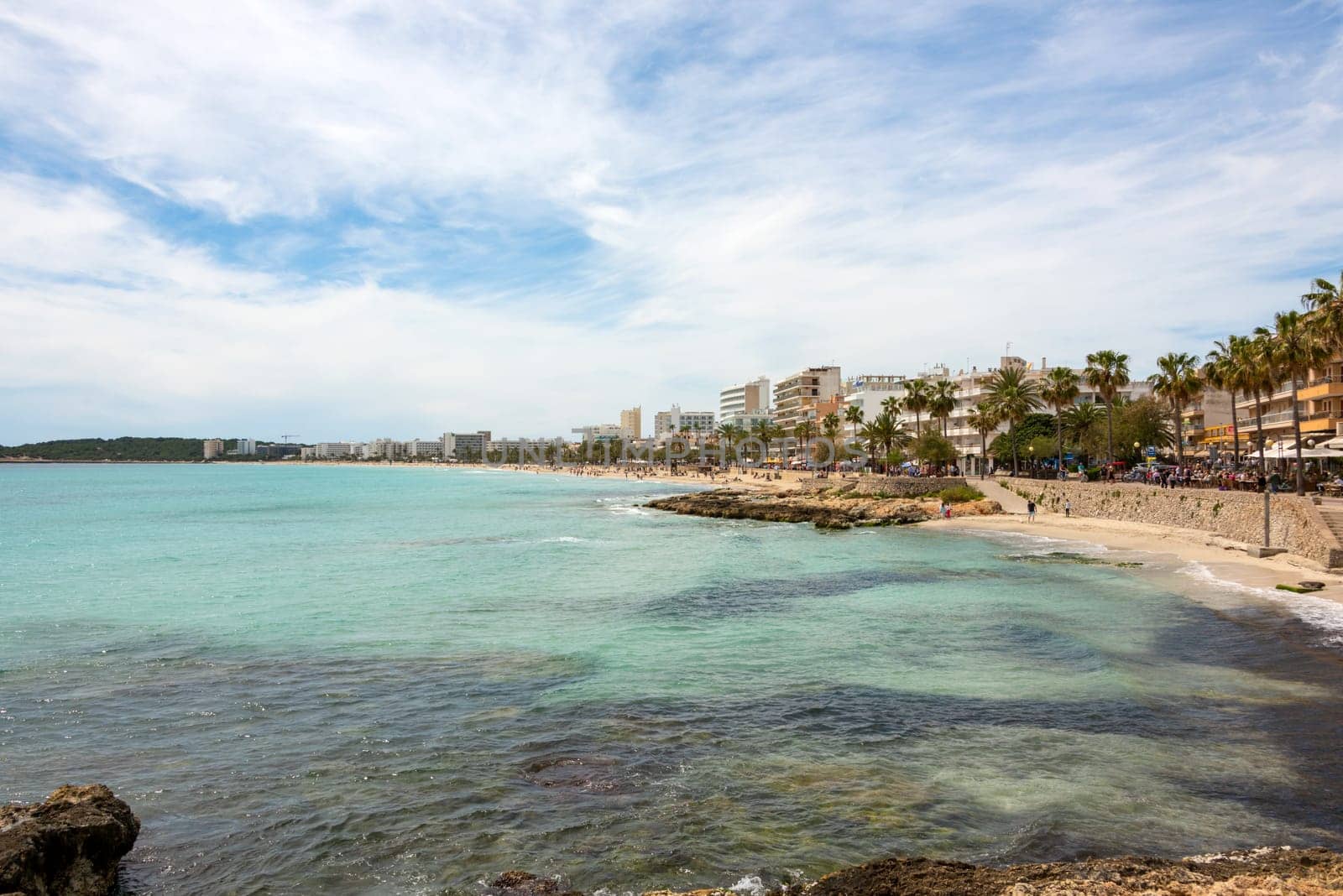 View over the turquoise Mediterranean to the big beach of Cala Millor with its promenade and the many hotels on the Spanish holiday island Mallorca
