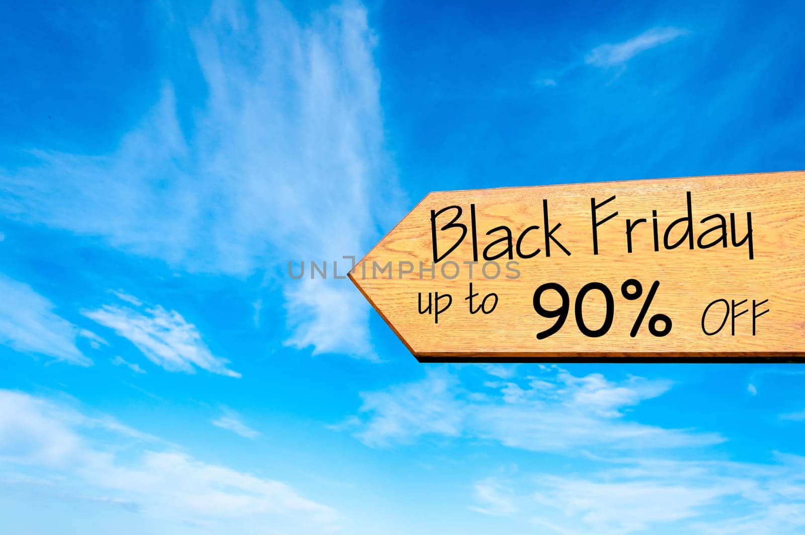 Wood arrow sign against clear blue sky with Black Friday up to 90% off message, Sales conceptual image