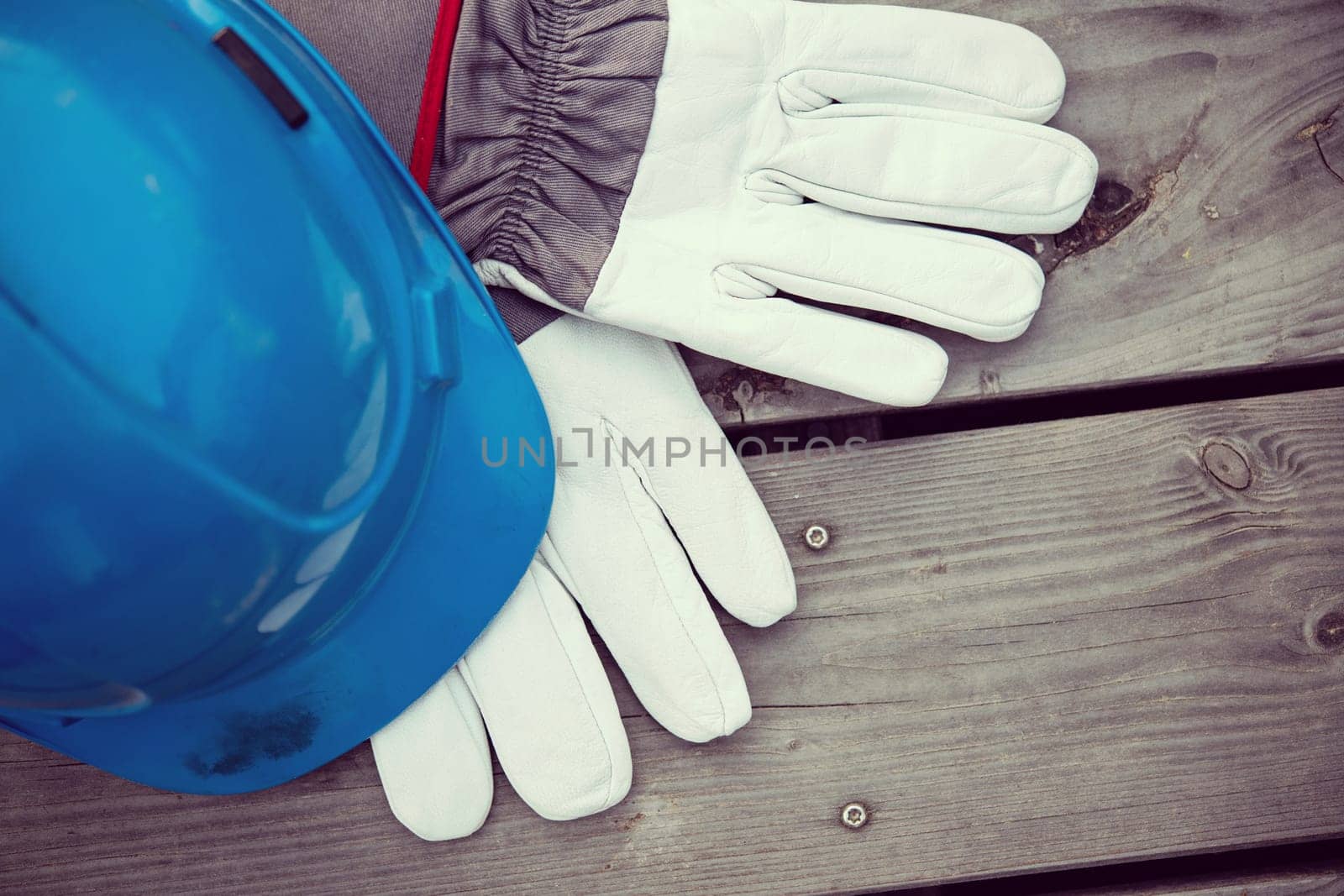 blue helmet and work gloves on wooden ground