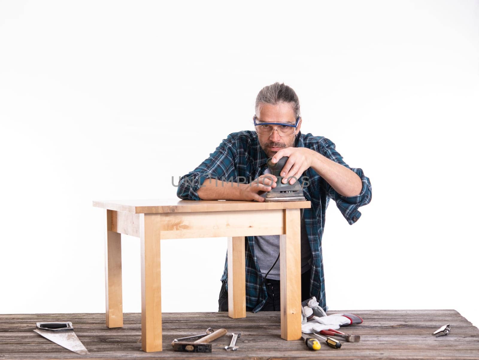 worker in blue plaid shirt repair a table