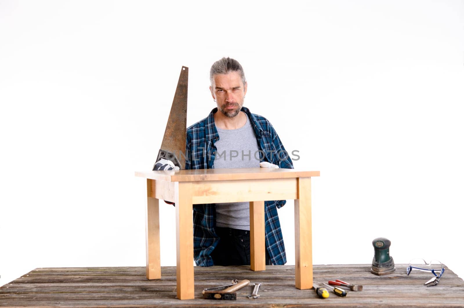 funny worker in blue plaid shirt repair a table