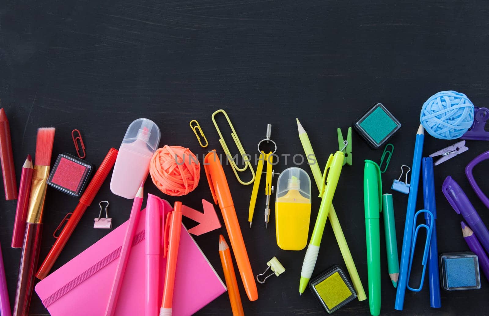 Colorful office / school supplies on a black background