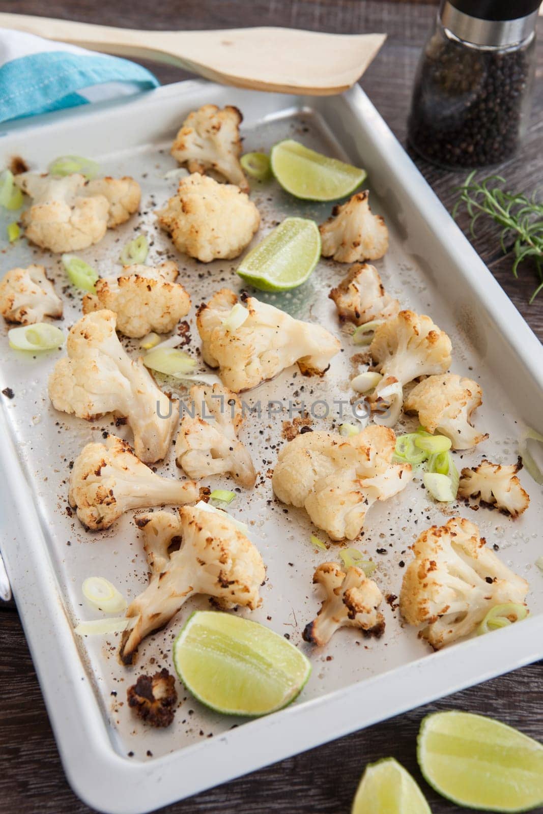 Baking sheet with roasted cauliflower and fresh lime