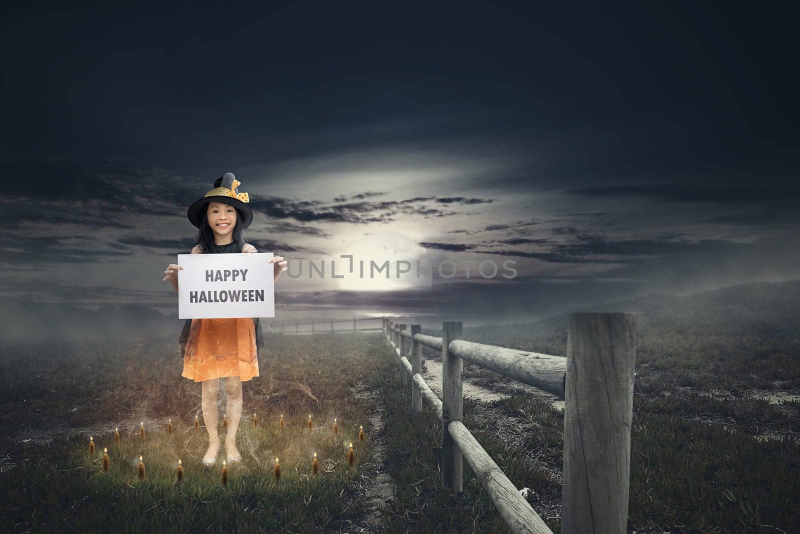 Cute asian little girl with Happy Halloween greeting. Halloween concept