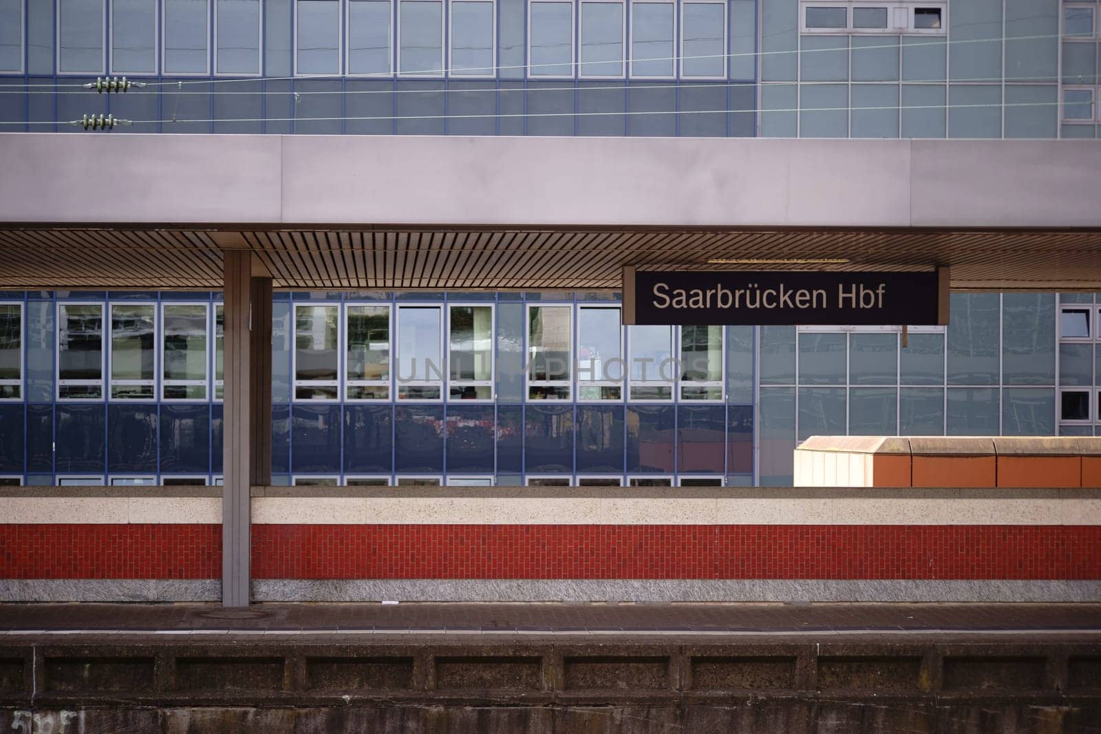 A platform from the main station in Saarbruecken with modern architecture in the background.