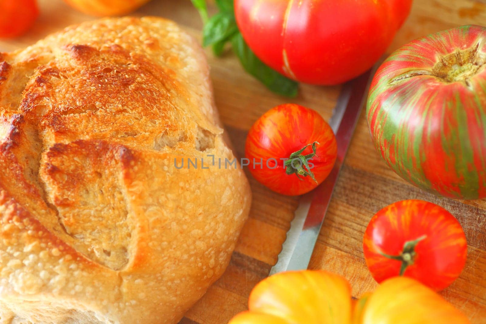 Loaf of artisan bread with varieties of heirloom tomatoes