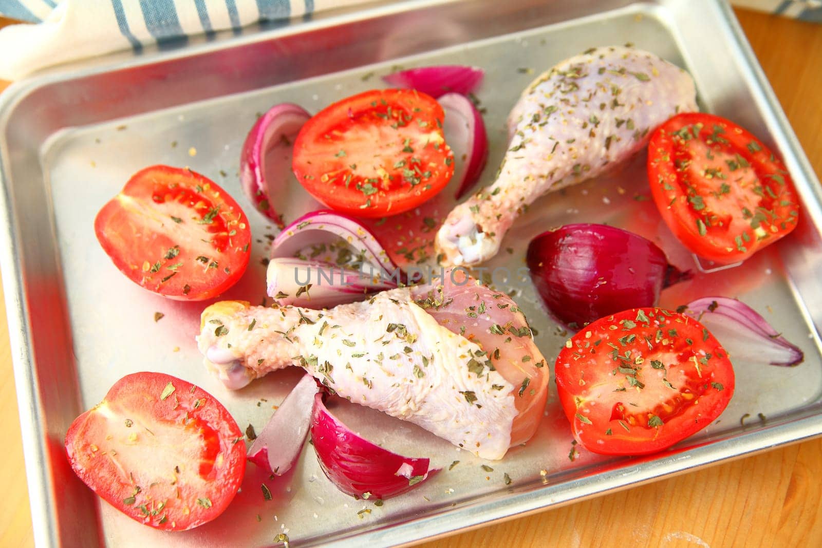 Overhead of chicken dinner for one with Roma tomatoes and red onions