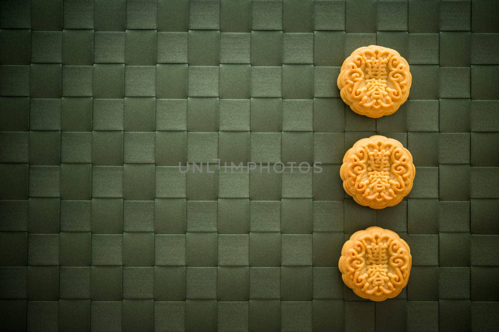 Traditional pastry mooncakes is eaten during the Mid-Autumn Festival. Flatlay table top view low light with copy space. The Chinese character represent "lotus paste""."