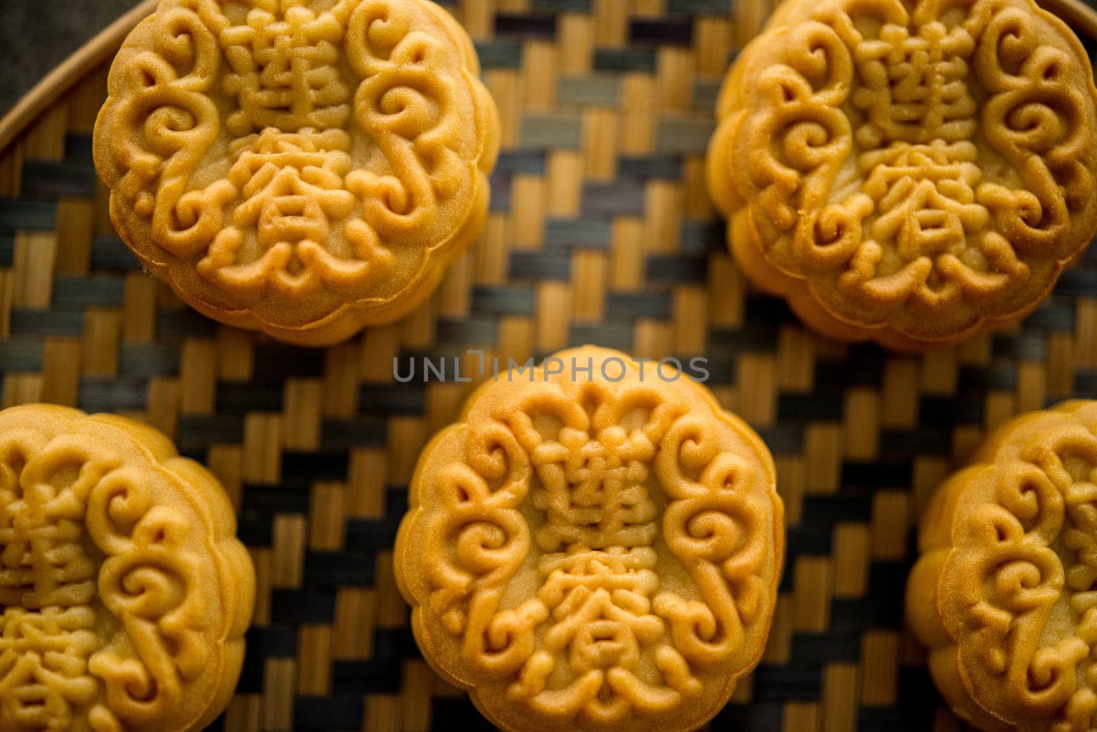 Traditional baked moon cakes is offered to friends or family during Mid-Autumn Festival. Flatlay on table, top down view dark background. The Chinese character represent "lotus paste""."