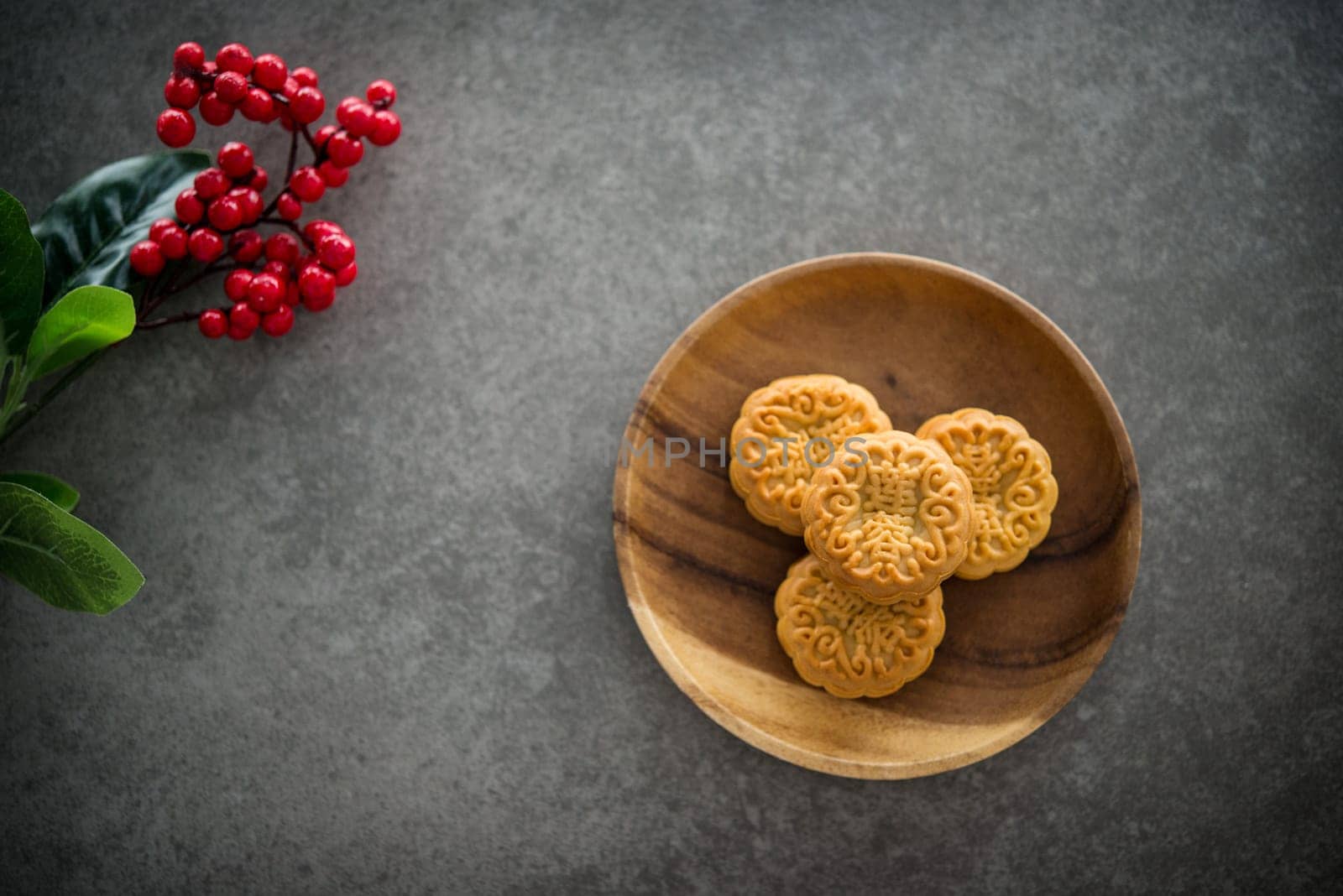 Traditional baked mooncakes is offered to friends or family during Mid-Autumn Festival. Flatlay on table top down view dark background with copy space. The Chinese character represent "lotus paste"" ."