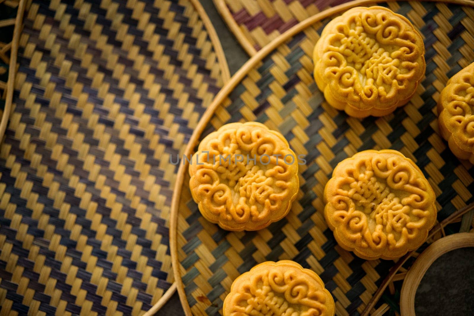 Traditional pastry moon cakes is offered to friends or family during Mid-Autumn Festival. Flatlay on table, top down view low light with copy space. The Chinese character represent "lotus paste""."