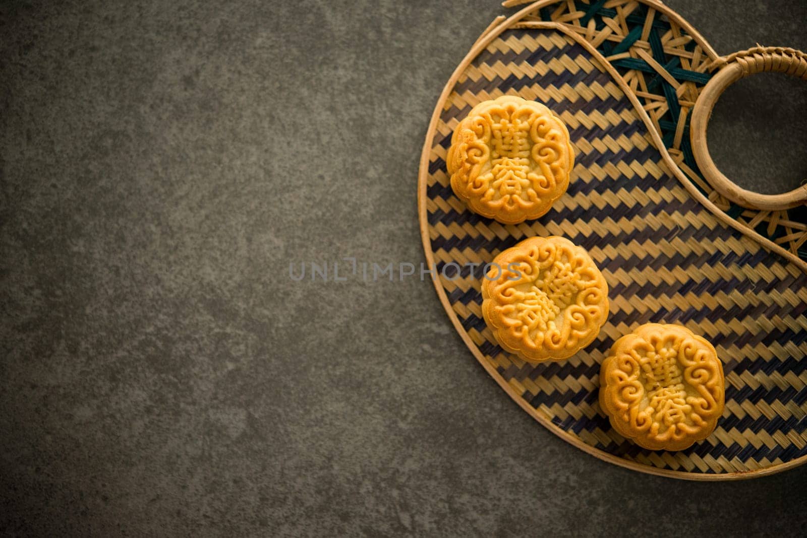 Traditional pastry mooncakes is offered to friends or family during Mid-Autumn Festival. Flatlay table top view dark light with copy space. The Chinese character represent "lotus paste""."