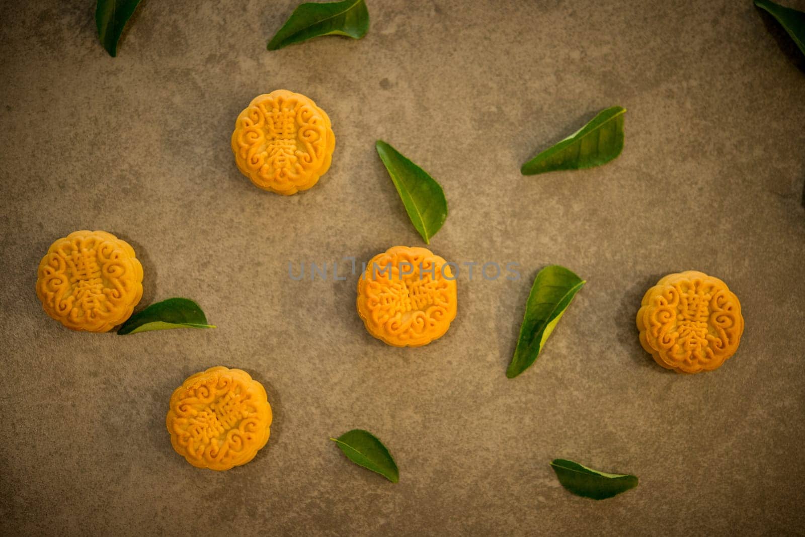 Traditional baked moon cakes is offered to friends or family during Mid-Autumn Festival. Flatlay table top view on dark background. The Chinese character represent "lotus paste""."