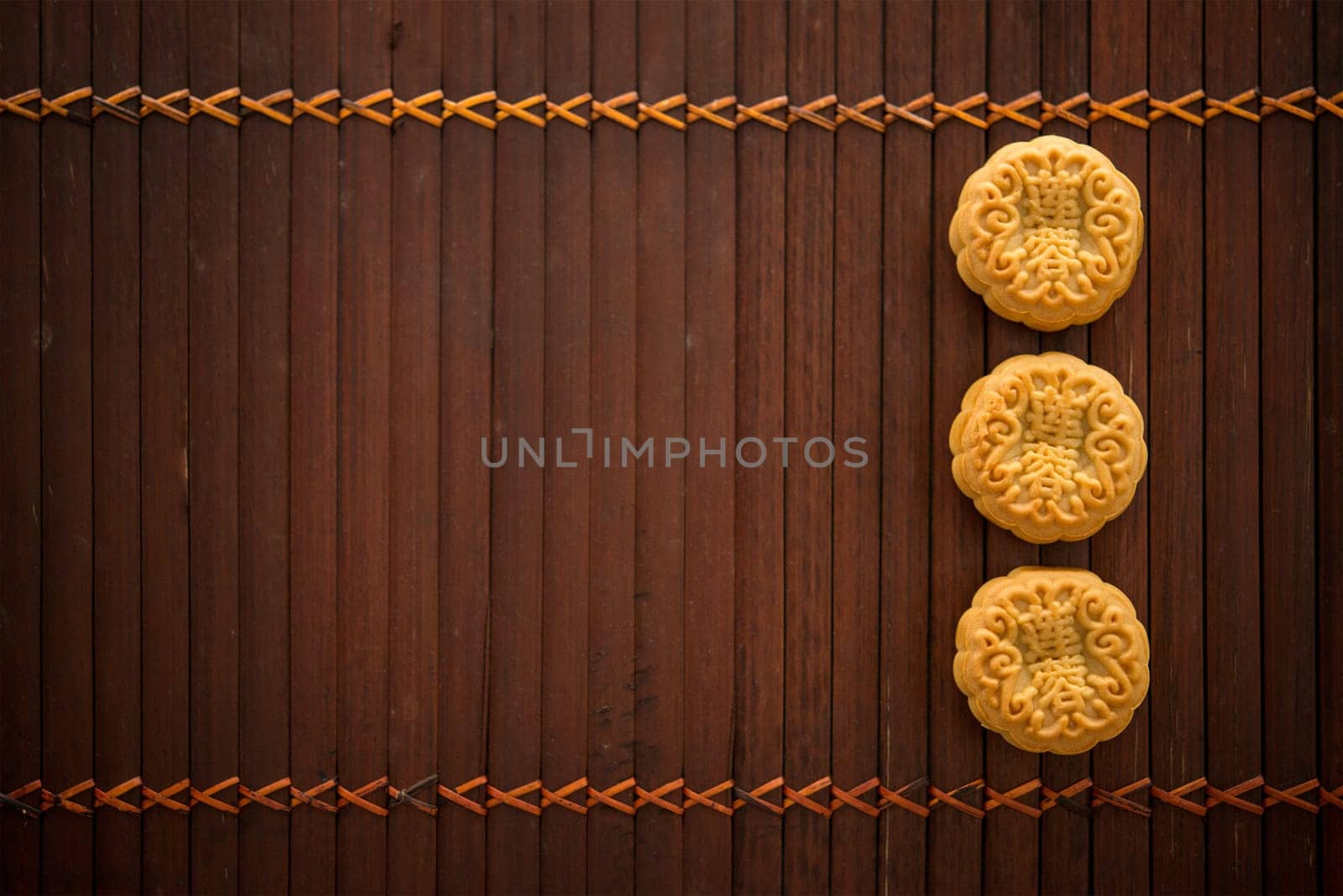 Traditional pastry moon cakes is offered to friends or family during Mid-Autumn Festival. Flatlay table top view low light with copy space. The Chinese character represent "lotus paste"" ."