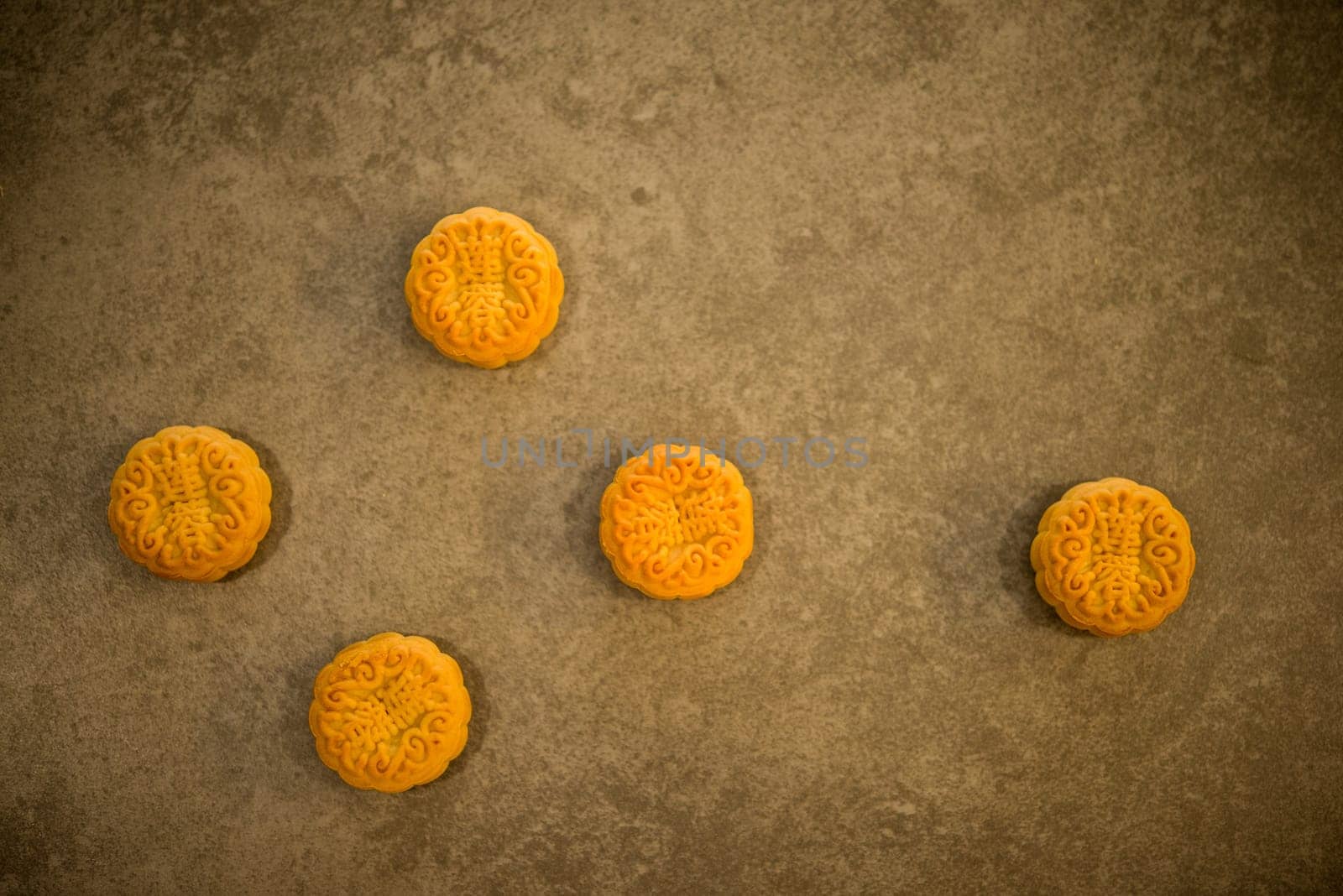 Traditional baked mooncakes is offered to friends or family during Mid-Autumn Festival. Flatlay table top view on dark background. The Chinese character represent "lotus paste""."
