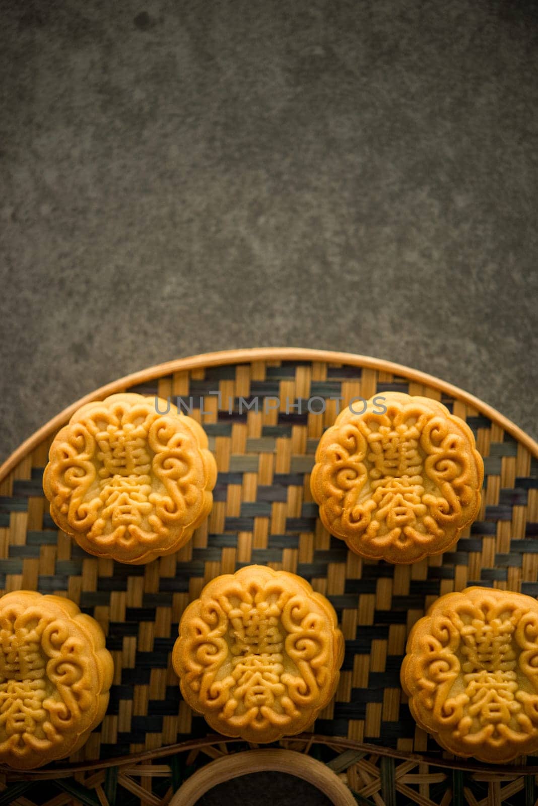 Traditional pastry mooncakes is offered to friends or family during Mid-Autumn Festival. Flatlay on table, top down view dark light with copy space. The Chinese character represent "lotus paste""."