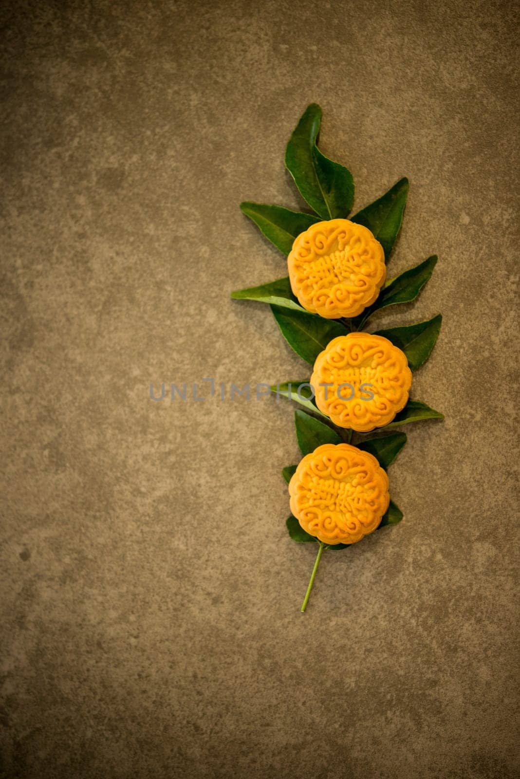 Mooncakes is traditional pastry eaten during the Mid-Autumn Festival. Flatlay on table top low light with copy space. The Chinese character represent "lotus paste""."