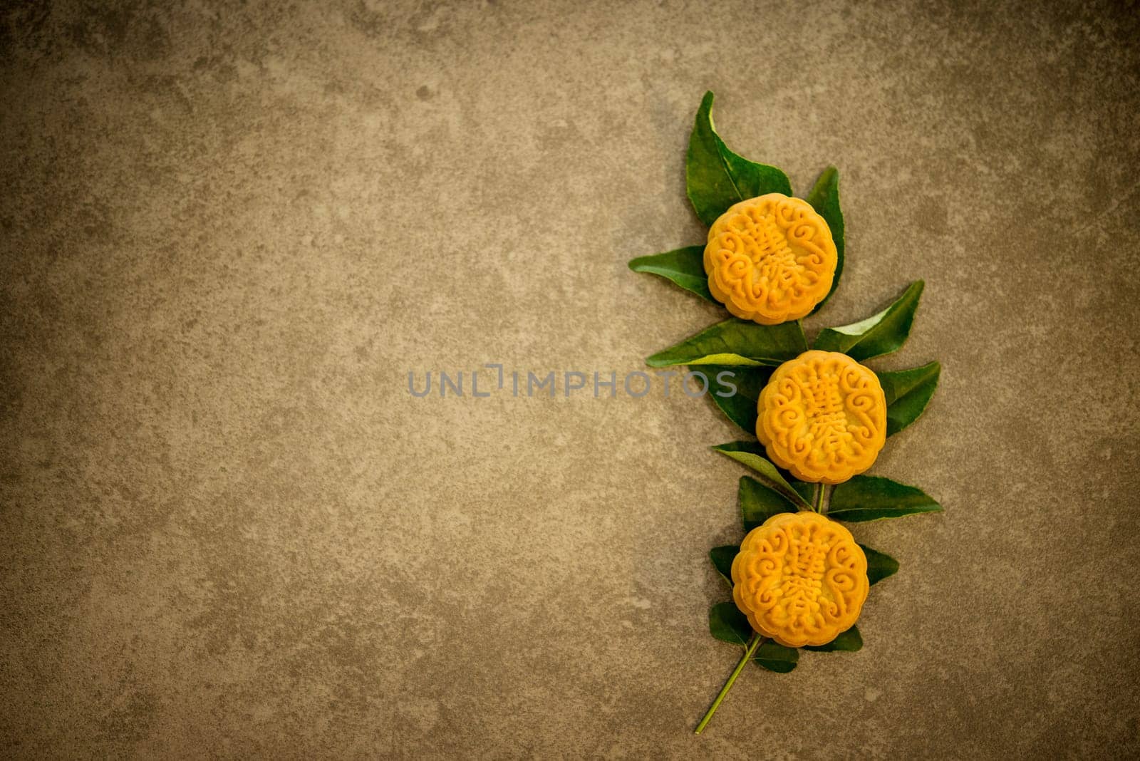 Moon cakes is traditional pastry eaten during the Mid-Autumn Festival. Flatlay on table top low light with copy space. The Chinese character represent "lotus paste""."