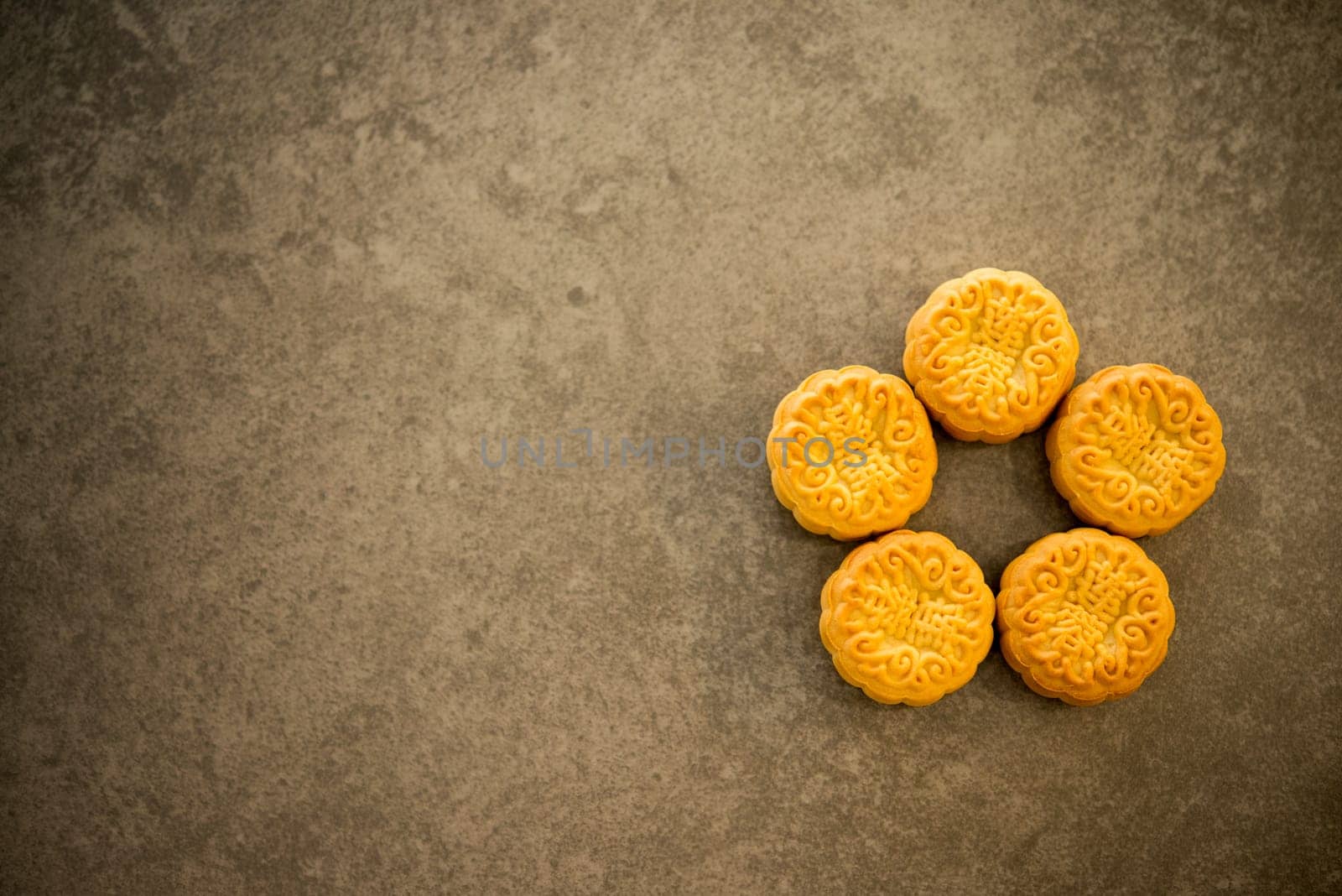Mooncake is traditional pastry eaten during the Mid-Autumn Festival. Flatlay on table, top down view with copy space. The Chinese character represent "lotus paste""."
