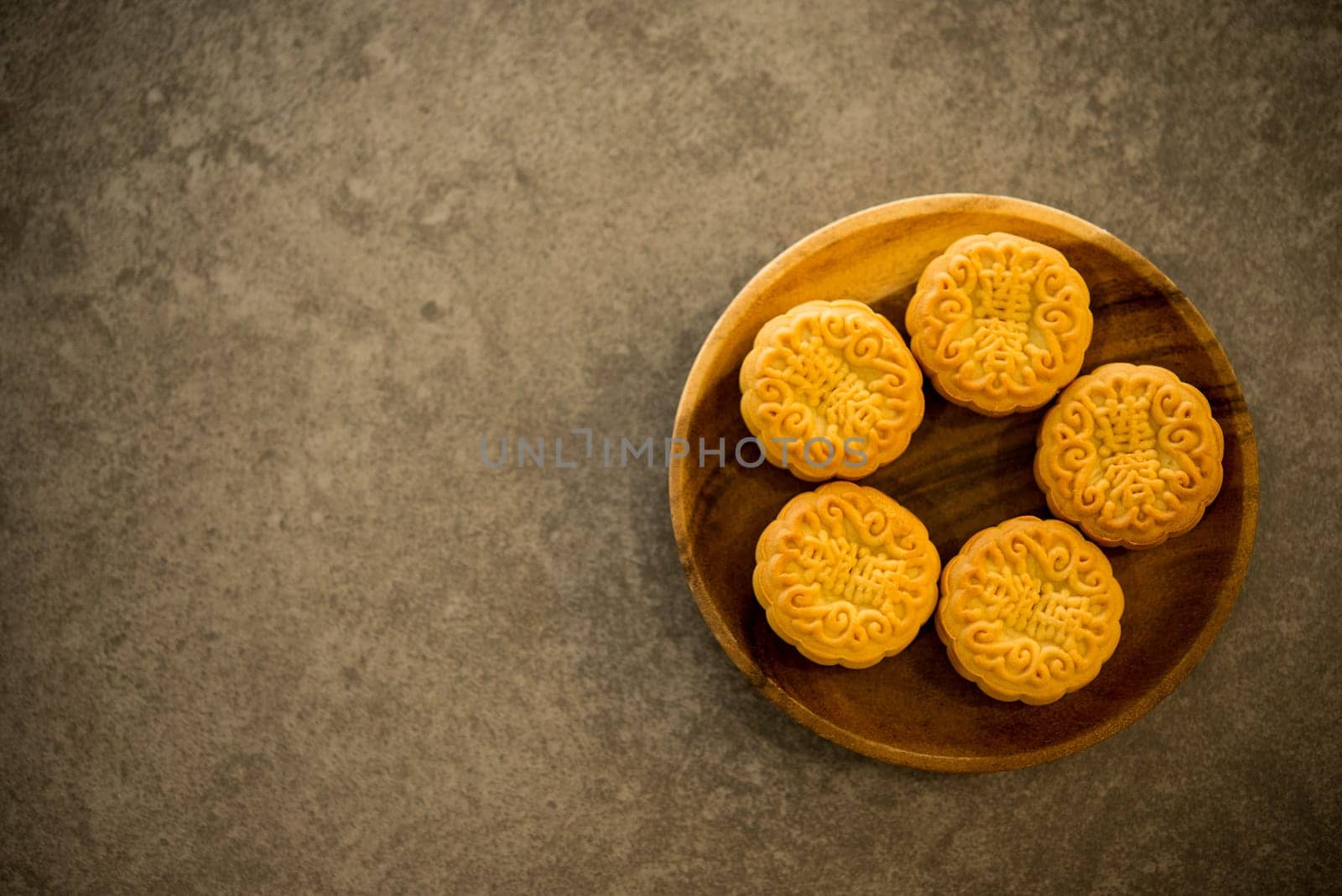 Moon cakes is traditional pastry eaten during the Mid-Autumn Festival. Flatlay on table, top down view with copy space. The Chinese character represent "lotus paste""."