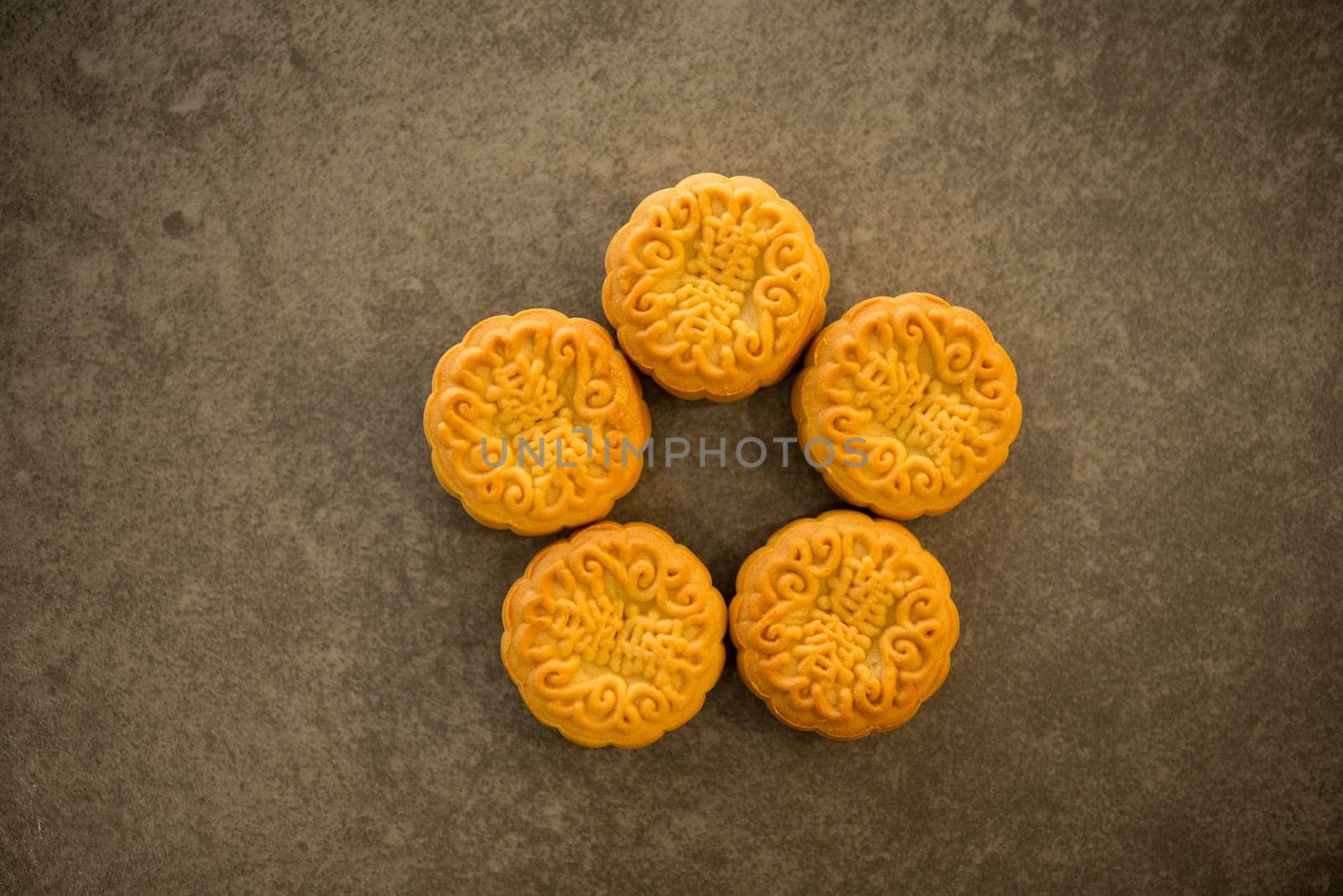 Mooncakes is offered to friends or family during Mid-Autumn Festival. Flatlay table top view on dark background. The Chinese character represent "lotus paste""."