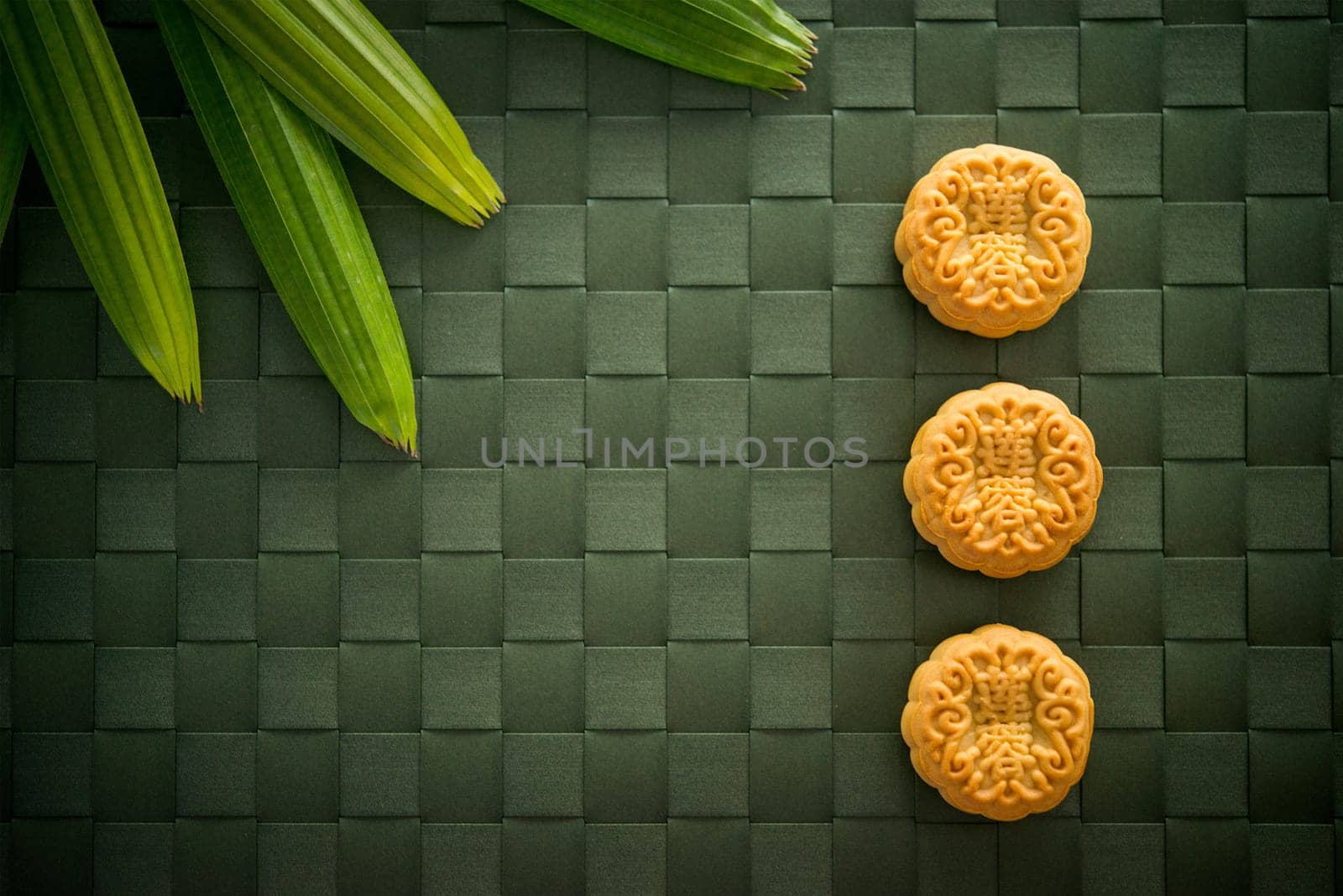 Traditional pastry moon cakes is eaten during the Mid-Autumn Festival. Flatlay table top view dark light with copy space. The Chinese character represent "lotus paste""."