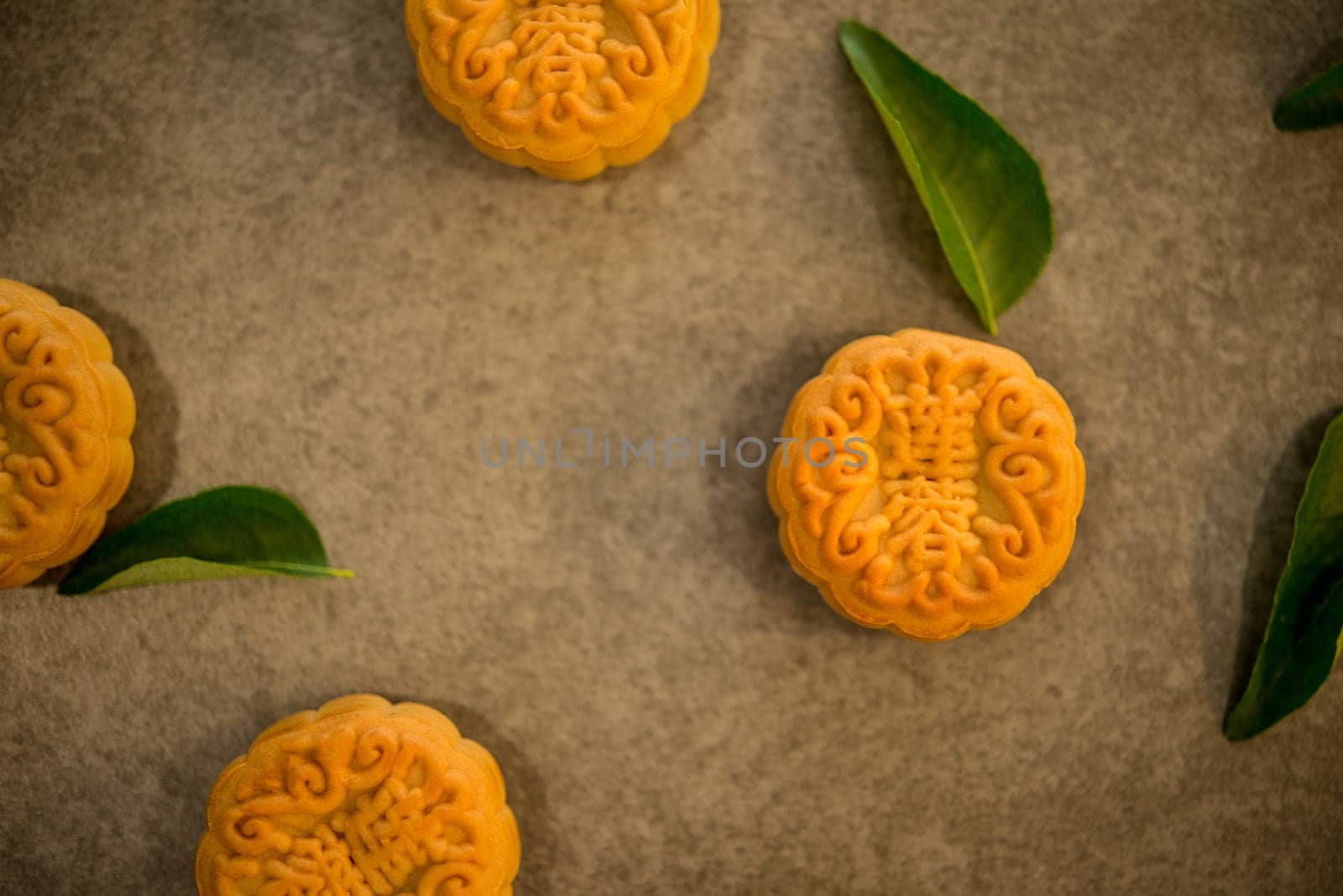 Traditional mooncakes is offered to friends or family during Mid-Autumn Festival. Flatlay table top view on dark background. The Chinese character represent "lotus paste""."