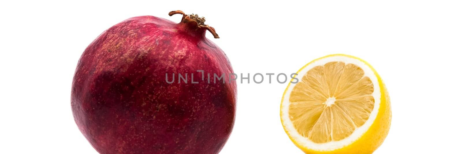 Ripe pomegranate and lemon on a white background. Close-up.