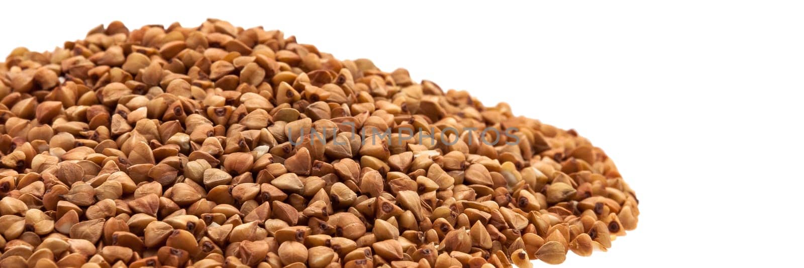 Buckwheat in a heap on the side on a white background.