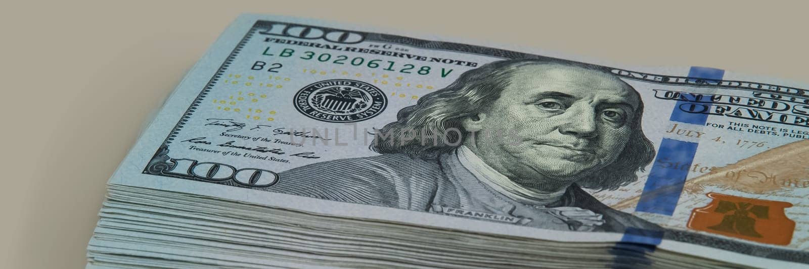 Part of the bundle with a bill shift of one hundred dollars. On a gray background. View at an angle.