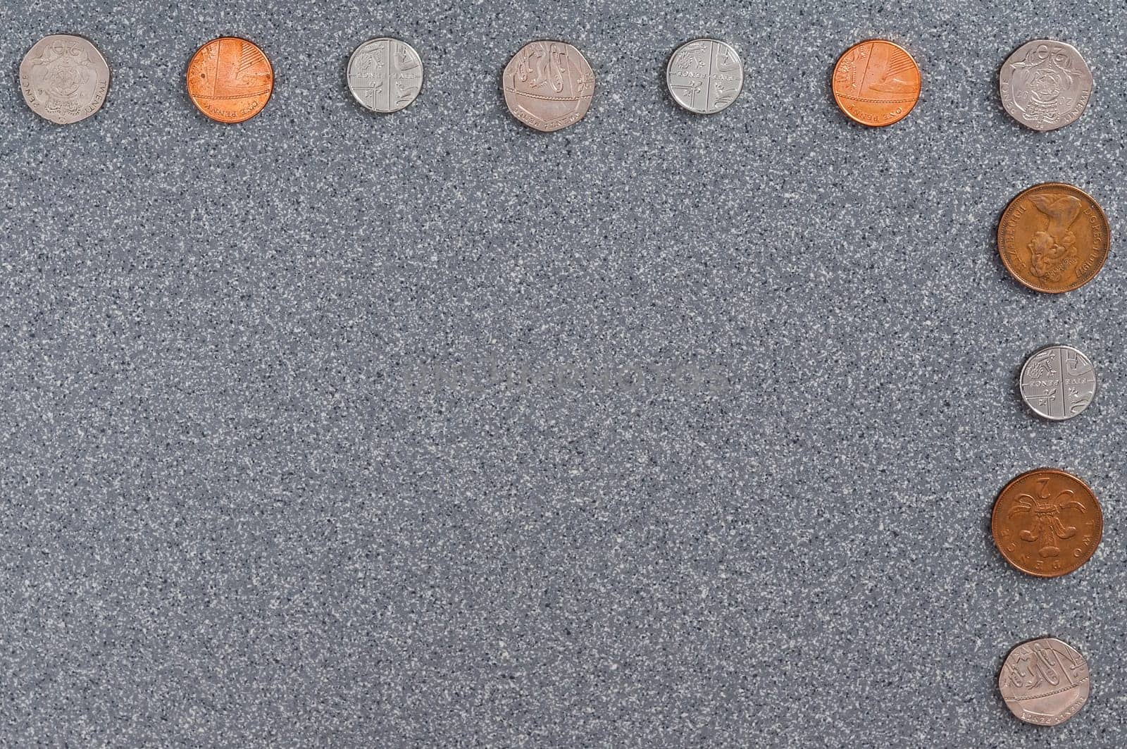 Coins of Great Britain of different dignity against the background of gray granite.