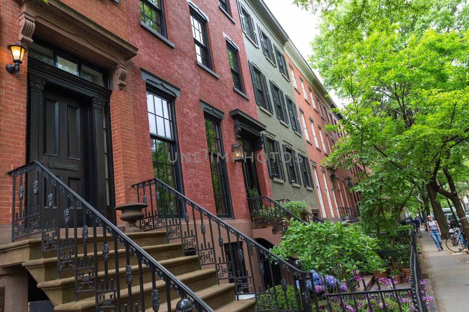 Row of old brownstone buildings along an empty sidewalk block in the Greenwich Village neighborhood of Manhattan, New York City, NYC, USA.