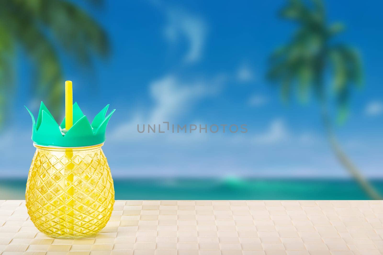 Drinking a fresh ananas juice from ananas glasses at he tropical beach. Summer holiday concept.