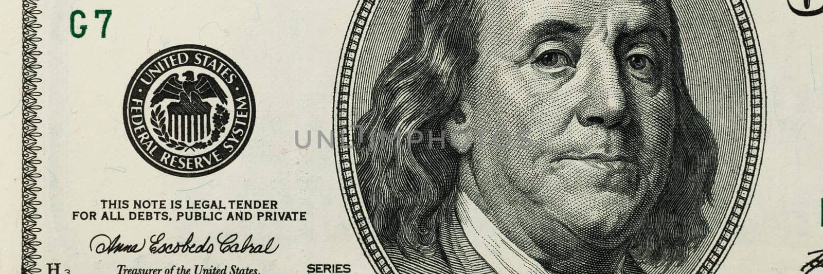 Part of the bill is one hundred US dollars. The left part. Close-up.